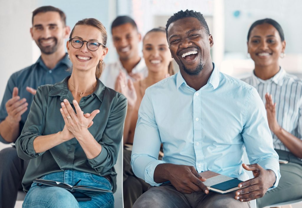 Workshop, applause and conference with audience in presentation for team building, training and awa